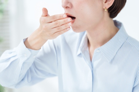 口元を手で押さえ口臭を気にする女性