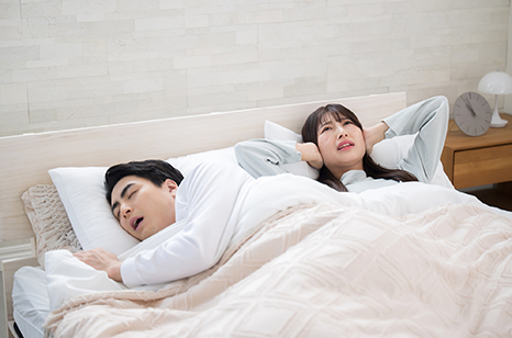 イビキがうるさくて耳をふさぐ女性