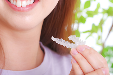 歯科用マウスピースを持つ若い女性