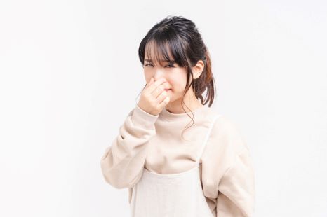 鼻をつまむ女性